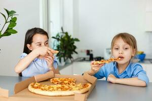 zwei glücklich wenig Kind Mädchen freunde Essen Pizza Scheiben. foto