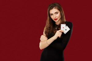 schön kaukasisch Frau im schwarz Kleid mit Poker Karten Glücksspiel im Kasino foto