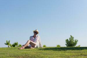 ein Frau Verlegung auf das Gras lesen ein Buch foto