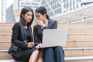 Geschäftsfrauen klatschen, während sie Laptop im Freien verwenden. Geschäfts- und Mitarbeiterkonzept foto