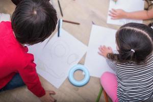 Gruppe von Vorschulschülern und Lehrern, die im Kunstunterricht auf Papier zeichnen. zurück zum Schul- und Bildungskonzept. Menschen und Lebensstile Thema. Zimmer im Kindergarten foto