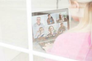 Frau Arbeiten von Zuhause haben Gruppe Videokonferenz auf Laptop foto