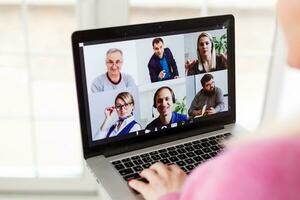 Frau Arbeiten von Zuhause haben Gruppe Videokonferenz auf Laptop foto