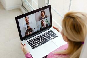 Frau Arbeiten von Zuhause haben Gruppe Videokonferenz auf Laptop foto