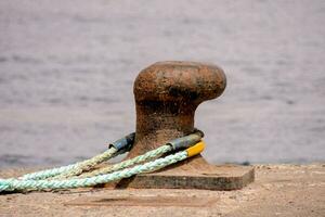 ein Seil gebunden zu ein Metall Objekt auf das Ufer foto