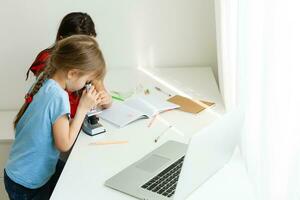 Lernen von heim, Zuhause Schule Kind Konzept. wenig Kinder Studie online Lernen von Zuhause mit Laptop. Quarantäne und Sozial Distanzierung Konzept. foto