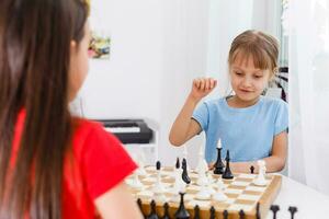 Zwei süße Kinder spielen zu Hause Schach foto