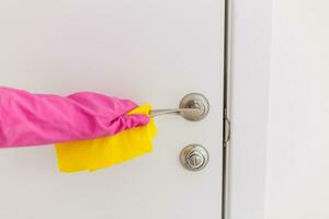 Frau Hand im schützend Gummi Handschuhe halten Mikrofaser Reinigung Tür handhaben, machen Reinigung und Desinfektion zum gut Hygiene foto