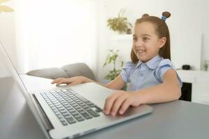 fröhlich süß Mädchen Kinder aufgeregt mit Computer Lernen Schularbeit. Kind genießen E-Learning im Urlaub beim heim. foto