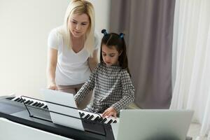 Frau, die ihrer Tochter beim Klavierspielen half, Körper und Knöpfe des Klaviers wurden digital modifiziert foto