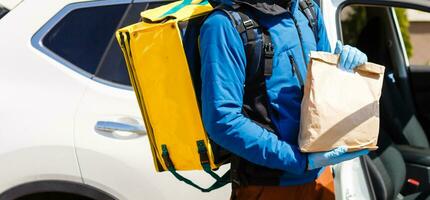 kontaktlos Essen Lieferung zu Kunden heim. Lieferung Bedienung Arbeiter mit Thermal- Rucksack schnell liefern Essen beim Haustür im Quarantäne von Restaurant, Supermarkt oder Cafe . online Bestellung Essen foto