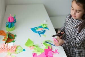 schön wenig Mädchen Schneiden Papier mit Schere auf das Kunst Lektion Klasse. Kinder Bildung Konzept. Kinder Basteln.zurück zu schoo foto