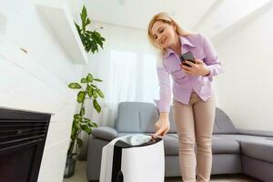 Luft Luftreiniger , Geschäft Frau verwenden Filter zum sauber Zimmer im ein Leben Zimmer foto