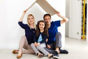 glücklich Familie Sitzung zusammen und Herstellung das Zuhause Zeichen foto