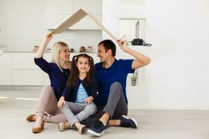 Konzept Gehäuse ein jung Familie. Mutter Vater und Kinder im ein Neu Zuhause foto