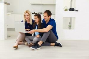 Familie oben Aussicht Sitzung auf Fußboden mit Laptop Computer im ihr Zimmer beim Zuhause foto