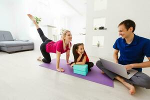 Ruhe jung Familie mit wenig Tochter trainieren Yoga zusammen, glücklich Eltern mit klein Vorschulkind Mädchen Kind meditieren lindern Negativ Emotionen auf Wochenende beim Zuhause foto