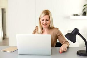 Frau Arbeiten beim Zuhause auf ein Laptop Computer foto