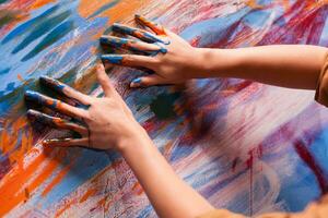 Hände von Künstler mit Farbe auf groß Segeltuch im Kunst Studio. modern Kunstwerk Farbe auf Leinwand, kreativ, zeitgenössisch und erfolgreich fein Kunst Künstler Zeichnung Meisterstück foto