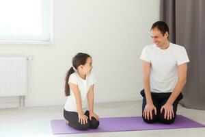 Vater und Tochter tun Yoga beim Zuhause foto