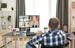 deaktiviert Mann im Rollstuhl während ein Video Konferenz mit Arbeit Kollegen. jung immobilisiert Freiberufler tun seine Geschäft online, mit hoch Technologie, Sitzung im seine Wohnung, Arbeiten entfernt im Besondere Bedingungen. foto