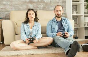 jung Paar entspannend spielen Video Spiele mit kabellos Regler. foto