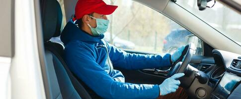 Lieferung Mann halten Papier Tasche mit Essen in der Nähe von das Auto, Essen Lieferung Mann im schützend Maske foto