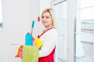 Reinigung Dame mit ein Eimer und Reinigung Produkte auf Büro Hintergrund. foto