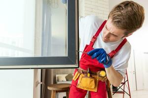 ein Handwerker Festsetzung Fenster im Neu Wohnung. foto