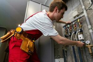 Instandhaltung Techniker Überprüfung Druck Meter zum Haus Heizung System. foto