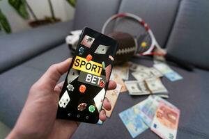 Sport Wetten Webseite im ein Handy, Mobiltelefon Telefon Bildschirm, Ball, Geld foto