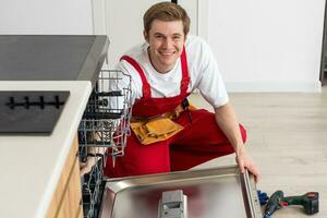 Reparatur von Geschirrspüler. Handwerker reparieren Geschirrspüler im Küche foto