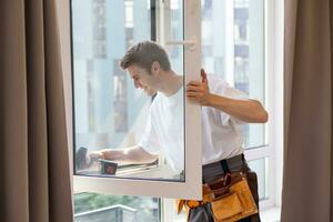 ein Handwerker Festsetzung Fenster im Neu Wohnung. foto