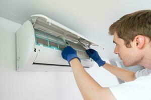 Techniker Bedienung Überprüfung und reparieren Luft Conditioner drinnen foto