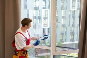 bauarbeiter, der fenster im haus installiert foto