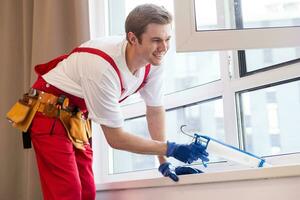 bauarbeiter, der fenster im haus installiert foto