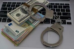 Polizei Handschellen Lüge auf viele Dollar Rechnungen isoliert auf schwarz Hintergrund. Verbrechen. Gerechtigkeit und Geld. Konzept von Verbrechen und Korruption mit Handschellen. foto