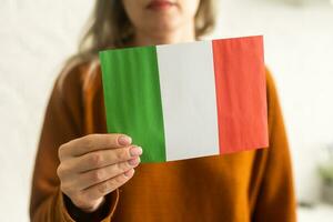 Person halten ein Italienisch Flagge auf ein Weiß Hintergrund foto