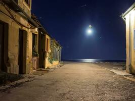 Straße zu das Meer im alt Stadt, Dorf beim Nacht ai generativ foto