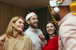 Neu Jahre Party von verschiedene verwitwet Freunde, Männer und Frauen schließen oben Tanzen und glücklich lächelnd und umarmen, feiern Neu Jahr im das Leben Zimmer in der Nähe von das Weihnachten Baum. foto