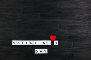 Inschrift Valentinsgrüße Tag auf ein schwarz hölzern Hintergrund foto