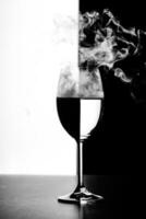 ein Glas Wasser und Rauch auf einem schwarzen und weißen Hintergrund foto