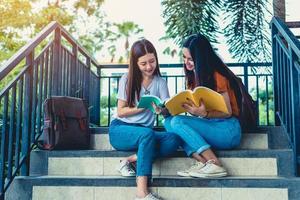 zwei asiatische Schönheitsmädchen, die zusammen Bücher für die Abschlussprüfung lesen und unterrichten. Student lächelt und sitzt auf der Treppe. Bildung und zurück zum Schulkonzept. Lifestyle- und People-Porträt-Thema foto