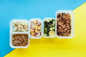 gesund Essen Lieferung Über Gelb und Blau Hintergrund. nehmen Weg von natürlich organisch Fitness Ernährung zum Diät. oben Sicht, eben legen. verpackt Täglich Mahlzeiten. foto