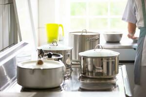 Metall Pfannen im ein industriell Küche. Kochen auf ein Fachmann Herd. foto