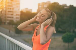 schön sportlich Frau genießt Hören Musik.getönt Bild. foto