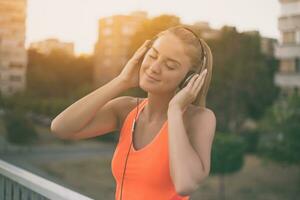 schön sportlich Frau genießt Hören Musik.getönt Bild. foto