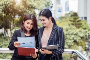 zwei junge asiatische geschäftsfrauen, die nach dem marketing in den dokumentendateiordner schauen, um gewinne oder verkaufs-Break-Even-Punkte zu analysieren. Business-Teamwork-Mitarbeiter des Lifestyle-Konzepts für berufstätige Frauen