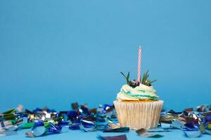 Geburtstag Cupcake mit drei Verbrennung Kerzen Über Blau Hintergrund foto