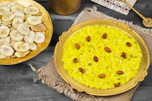 indisch würzig und knusprig Beliebt Frühstück Poha Chivda auf hölzern Hintergrund foto